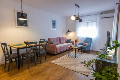 a living room with a table and a couch at Floret Suite in Podgorica
