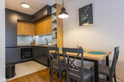 a kitchen and dining room with a table and chairs at Floret Suite in Podgorica
