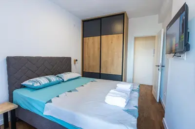 a bedroom with a large bed and a television at Floret Suite in Podgorica