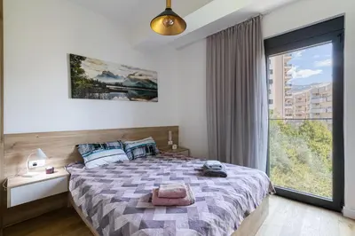 a bedroom with a bed and a large window at Aura Zafiro in Budva