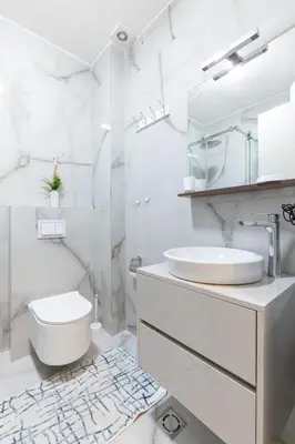 a white bathroom with a toilet and a sink at Aura Zafiro in Budva