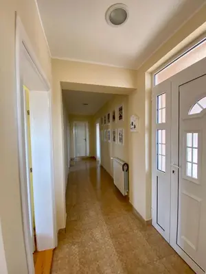 an empty hallway with a white door and a hallway at Apartman Buki in Bjeliši