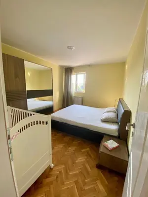 a small bedroom with a bed and a mirror at Apartman Buki in Bjeliši