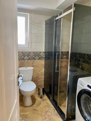 a bathroom with a toilet and a glass shower at Apartman Buki in Bjeliši