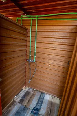 a wooden garage with green pipes on the wall at Camp River Skadar Lake in Gostilj