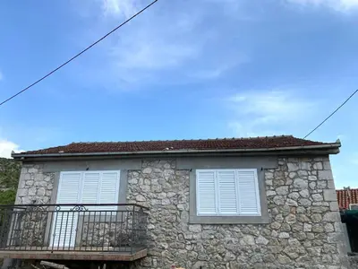 a stone house with white windows and a balcony at Stone house Kana-Skadar Lake in Dodoši