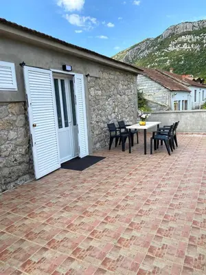 a patio with a table and chairs and a building at Stone house Kana-Skadar Lake in Dodoši