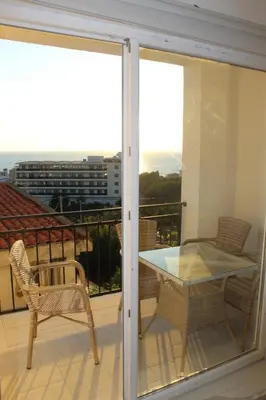 a patio with a table and chairs on a balcony at Lunis Dobra Voda in Dobra Voda