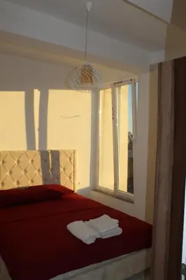 a bedroom with a red bed with towels on it at Lunis Dobra Voda in Dobra Voda