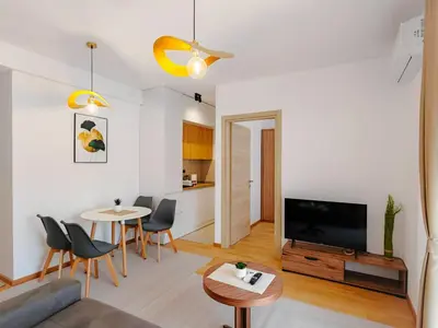 a living room with a television and a table and chairs at Modern City Apartment Budva3-Central Location,5 min to Beach in Kravlja