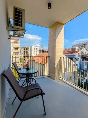 a balcony with a table and a view of a city at Modern City Apartment Budva 4-Central Location,5 min to Beach in Budva