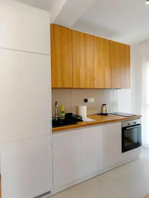 a white kitchen with wooden cabinets and a sink at Modern City Apartment Budva 4-Central Location,5 min to Beach in Budva