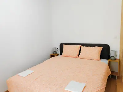 a bedroom with a bed with orange sheets and pillows at Modern City Apartment Budva 4-Central Location,5 min to Beach in Budva