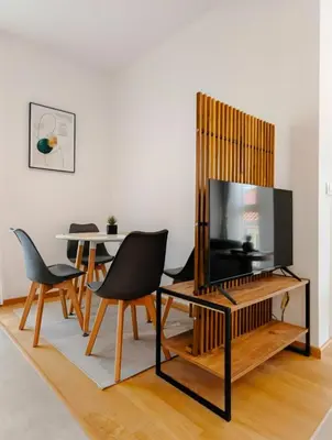 a living room with a tv and a table and chairs at Modern City Apartment Budva 4-Central Location,5 min to Beach in Budva