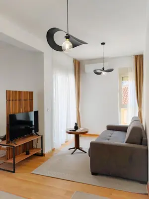 a living room with a couch and a flat screen tv at Modern City Apartment Budva 4-Central Location,5 min to Beach in Budva