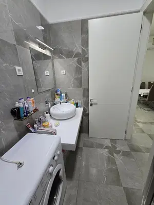 a bathroom with a sink and a washing machine at Апартаменты Дельмар in Becici