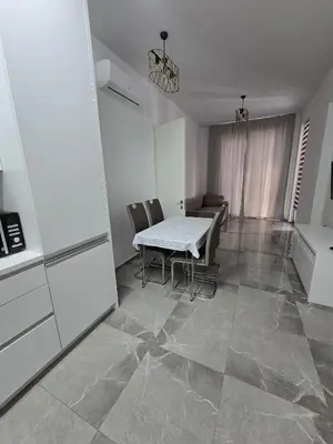 a kitchen and dining room with a table and chairs at Апартаменты Дельмар in Becici