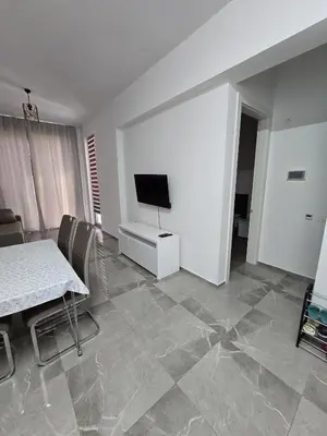 a living room with a flat screen tv and a table at Апартаменты Дельмар in Becici