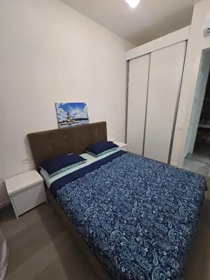 a bedroom with a bed with a blue comforter at Апартаменты Дельмар in Becici