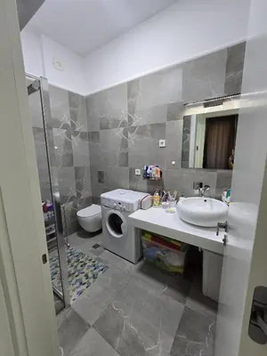 a bathroom with a sink and a washing machine at Апартаменты Дельмар in Becici