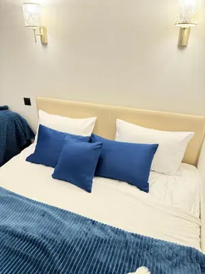 a bed with blue and white pillows on it at Aurora Apartment in Petrovac na Moru