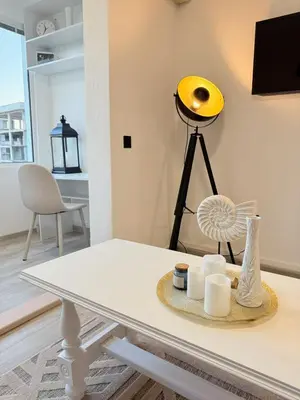 a living room with a table and a yellow light at Aurora Apartment in Petrovac na Moru