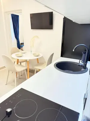 a kitchen with a sink and a table with chairs at Aurora Apartment in Petrovac na Moru