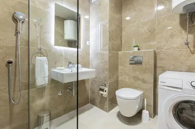 a bathroom with a toilet and a sink and a washing machine at Princess Milena Apartments - Apartment Milena in Becici