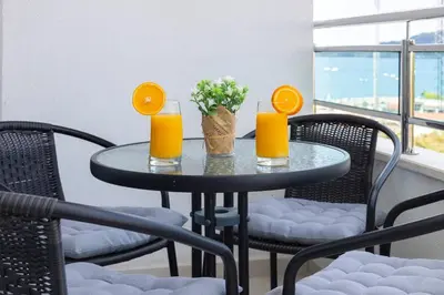 a table with two glasses of orange juice and flowers on it at Princess Milena Apartments - Apartment Milena in Becici