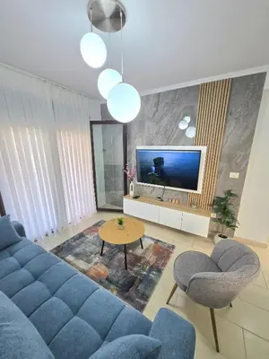 a living room with a blue couch and a tv at Apartment Nemanja by Princess Milena in Becici
