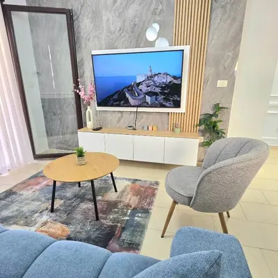 a living room with a blue couch and a tv at Apartment Nemanja by Princess Milena in Becici