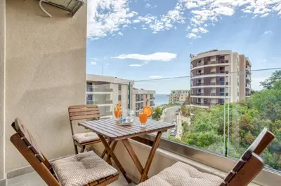 a balcony with a wooden table and chairs and a window at Princess Milena Apartments - Studio Balsa in Becici