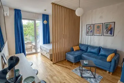 a living room with a blue couch and a bed at Princess Milena Apartments - Studio Balsa in Becici