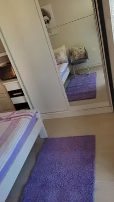 a bedroom with purple carpeting and a bed and a mirror at Apartments Peranovic in Kotor