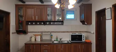 a kitchen with wooden cabinets and a sink and a microwave at Apartments Peranovic in Kotor