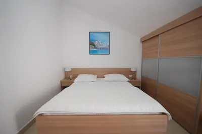 a bedroom with a large bed and a wooden cabinet at Pansion Anita in Budva