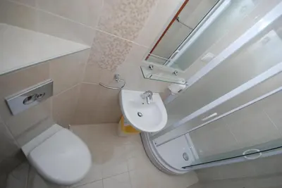 a bathroom with a sink and a toilet and a mirror at Pansion Anita in Budva