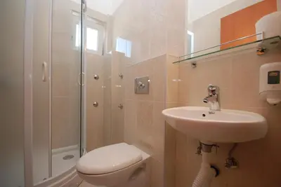 a bathroom with a toilet and a sink and a shower at Pansion Anita in Budva