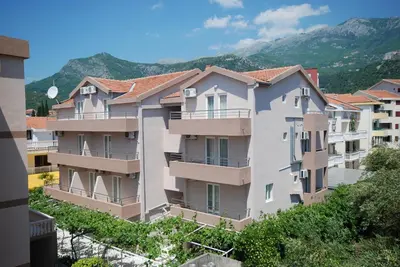 a row of apartment buildings with mountains in the background at Pansion Anita in Budva