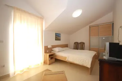 a small bedroom with a bed and a television at Pansion Anita in Budva