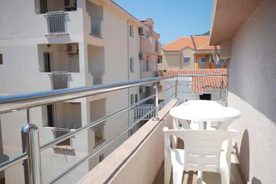 a balcony with a white table and chairs on it at Pansion Anita in Budva