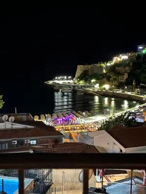 a view of a marina at night with lights at gadina inn in Ulcinj