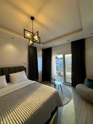 a bedroom with a bed and a couch and a chandelier at gadina inn in Ulcinj