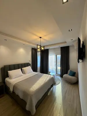 a bedroom with a large bed and a chair at gadina inn in Ulcinj