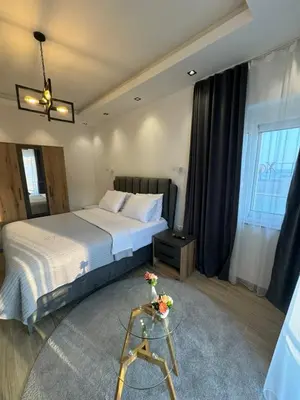 a bedroom with a bed and a table with flowers on it at gadina inn in Ulcinj