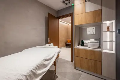 a bathroom with a large bed and a sink at Nomio in Tivat