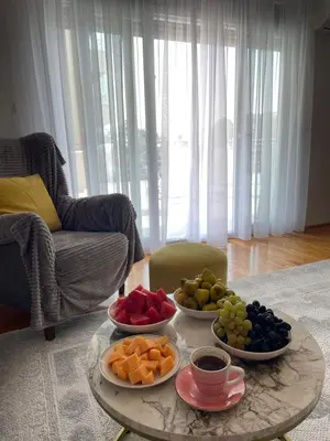 a coffee table with three bowls of fruit on it at Viktorija Apartment Petrovac in Petrovac na Moru