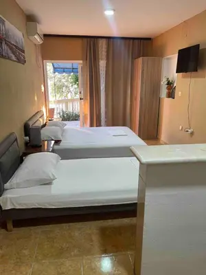 a room with three beds in it with a window at Fontana Apartments 1A in Ulcinj