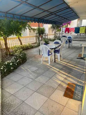 a patio with tables and chairs under a blue canopy at Fontana Apartments 1A in Ulcinj