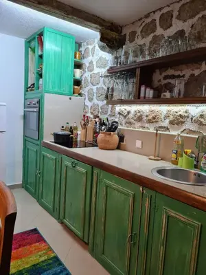 a kitchen with green cabinets and a sink at Charming 3 Bedroom House in Skaljari Montenegro with Garden View in Škaljari
